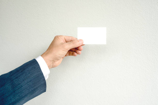 istock Business man hand holding name card on gray background. 900737828
