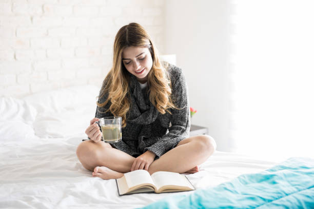 istock Cozy girl reading and drinking tea 900739364