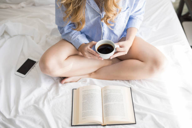 istock Woman reading a book in bed 900739586