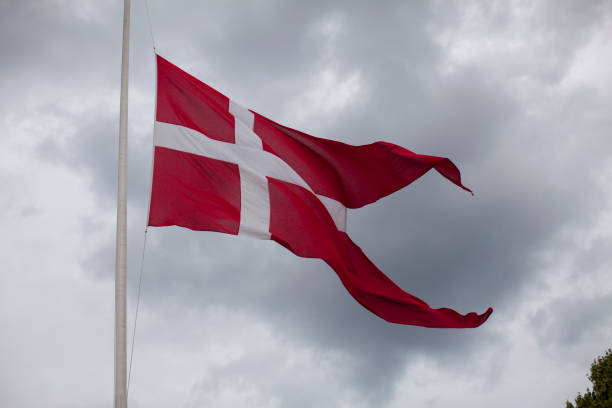 istock Denmark flag against stormy sky 900742106