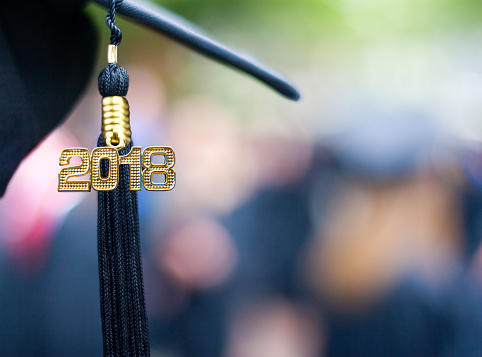 A black 2018 Tassel on a mortarboard hat representing the class of 2018 at a graduation ceremony