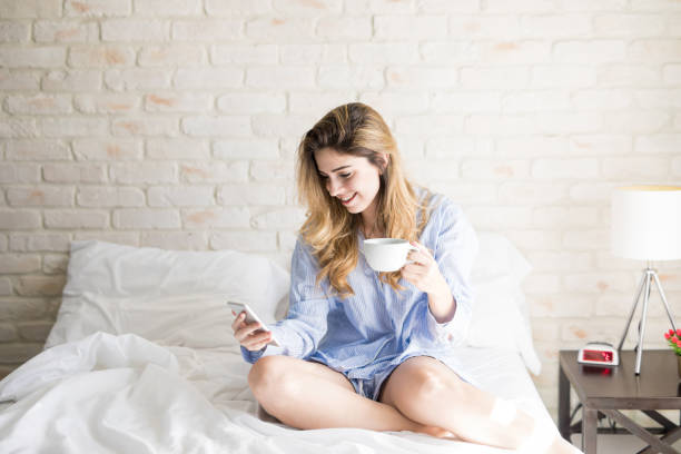 istock Latin woman drinking coffee in bed 900745710