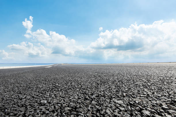 istock asphalt road and blue sky with white clouds by the lake 900746882