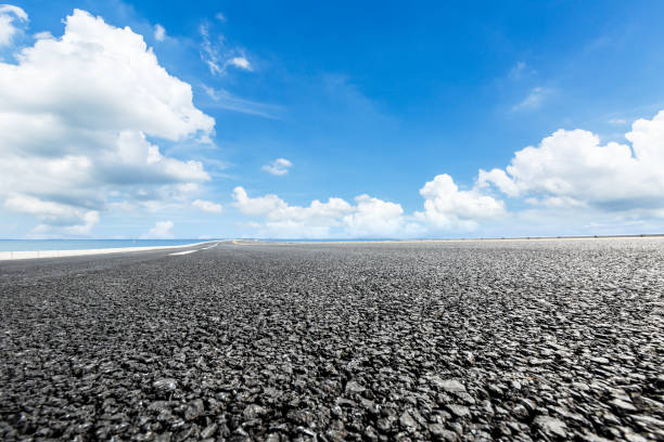 istock asphalt road and blue sky with white clouds by the lake 900746912