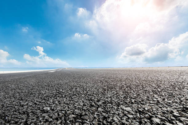 istock asphalt road and blue sky with white clouds by the lake 900747002
