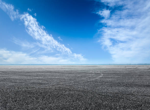 istock asphalt road and blue sky with white clouds by the lake 900749130