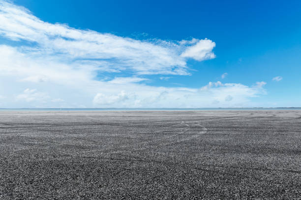 istock asphalt road and blue sky with white clouds by the lake 900749348