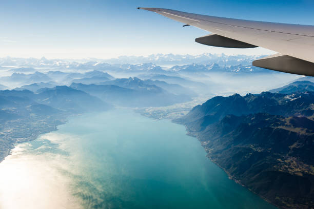 Alpine scenery from the air through the airplane window Flying over Europe on a sunny spring morning. switzerland photos stock pictures, royalty-free photos & images