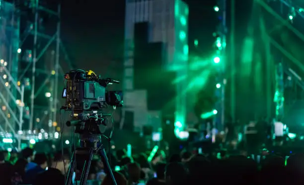 Photo of Crowd of hands up concert stage lights and people fan audience silhouette raising hands in the music festival rear view with spotlight glowing effect