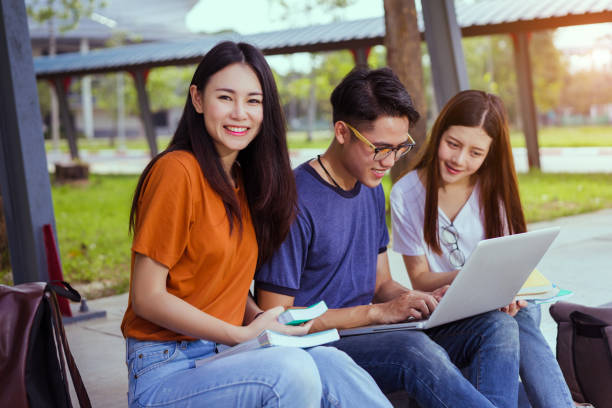 istock Students young asian together reading book study smiling with tablet,laptop computer at university high school campus,college in summer holiday relaxation 900774388