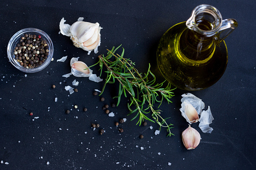 Fresh Herbs, Garlic, Pepper and Oil Olive on Black Background