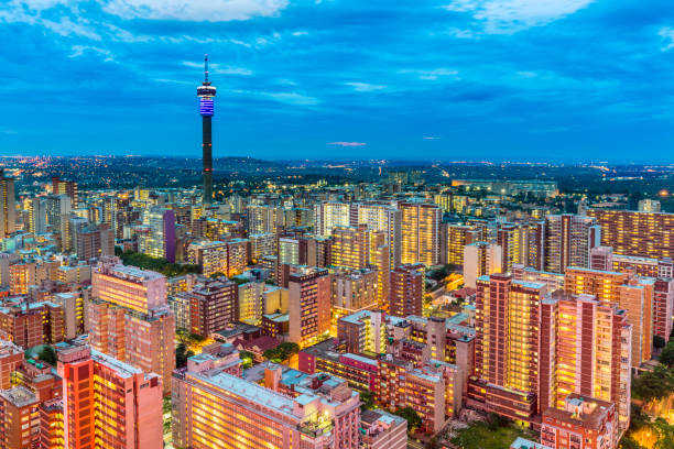Johannesburg sunset cityscape with Hillbrow tower Johannesburg cityscape in the evening dusk across Hillbrow residential suburb of towering apartments. The iconic Hillbrow communication tower seen in the midst. Johannesburg is one of the forty largest metropolitan cities in the world, and the world's largest city that is not situated on a river, lakeside, or coastline. It is also the source of a large-scale gold and diamond trade, due being situated in the mineral-rich Gauteng province. johannesburg photos stock pictures, royalty-free photos & images