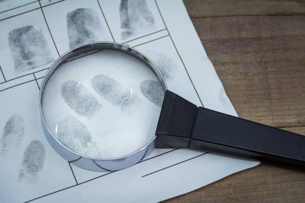 istock Fingerprints on paper with a magnifying glass 900788984