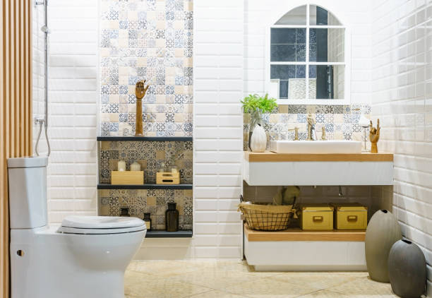 istock Modern spacious bathroom with bright tiles with toilet and sink. Side view 900792424
