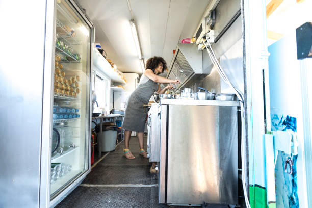 istock Smiling female food van worker making sandiches 900799710