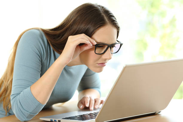 istock Woman with eyesight problems to read on line content 900807188