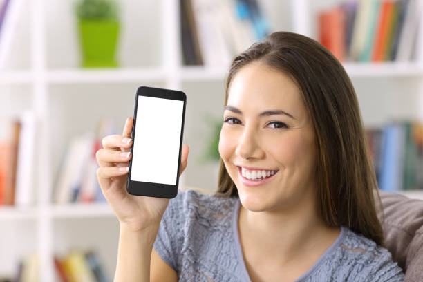 istock Lady showing blank smart phone screen at home 900807282