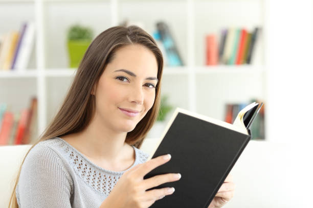 istock Lady reading a book and looking at you 900807722