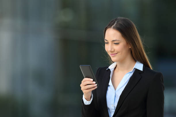istock Executive checking a smart phone on the street 900807770
