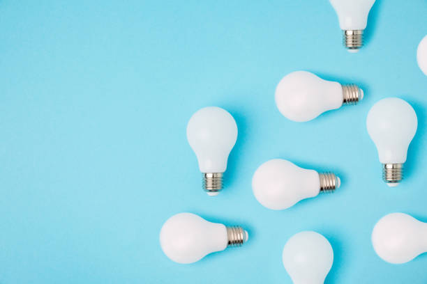 istock flat lay with arranged white light bulbs isolated on blue 900813390