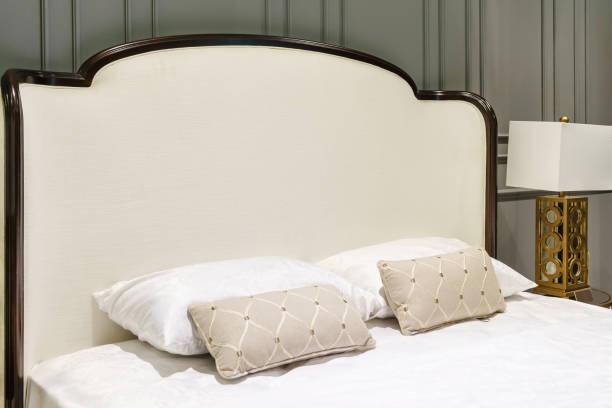 istock Bed maid-up with clean white pillows and bed sheets in beauty room, Close-up. 900813402