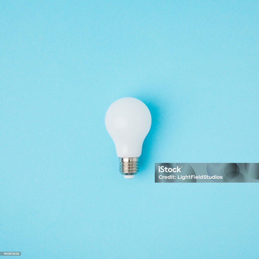 close up view of white light bulb isolated on blue Light Bulb Stock Photo