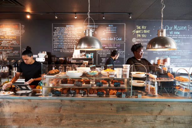 staff working behind counter in busy coffee shop - cafeteria imagens e fotografias de stock