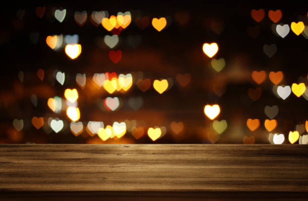 istock Empty rustic table in front of Valentine's day romantic glitter bokeh background with many hearts lights. Ready for product display montage. 900817666