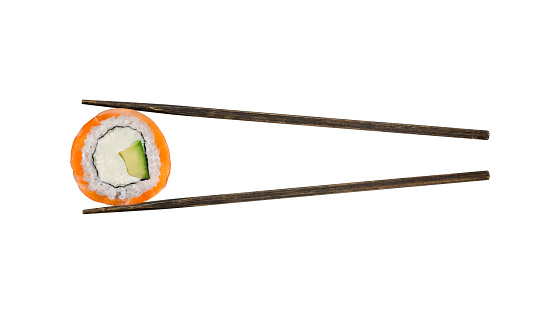 Wooden chopsticks hold salmon sushi
