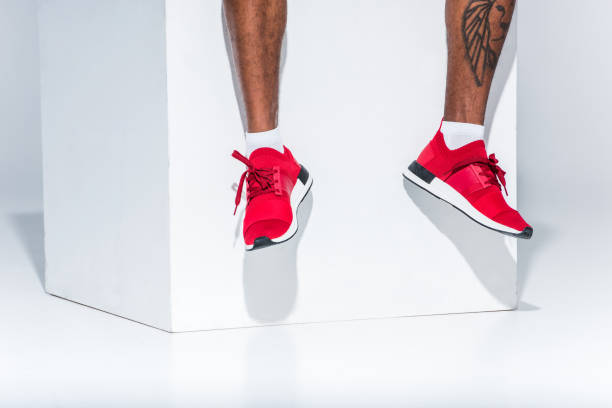 man in red sneakers sitting on grey