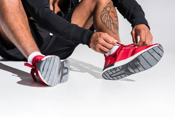istock sportsman tying shoelaces on grey 900825388