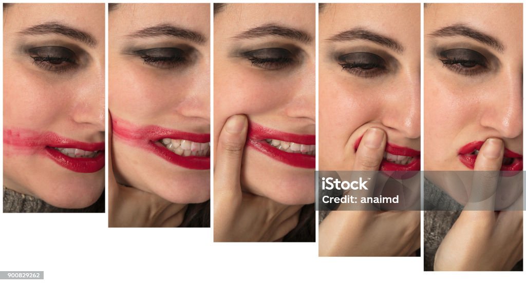 Facial expressions of an angry depressed woman Facial expressions of an angry depressed woman as in a series of five showing her placing her thumb over her lips and smearing her red lipstick across her cheek Adult Stock Photo