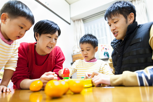 A Japanese family is playing games all together at home.