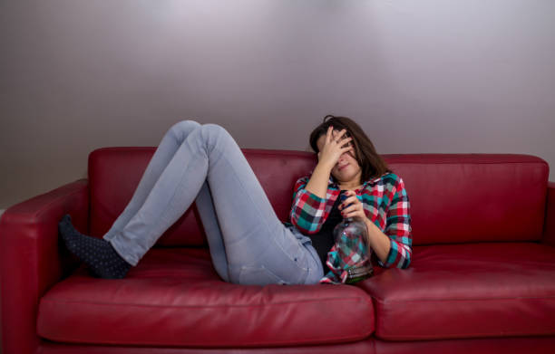 istock Young drunk woman sitting in the sofa 900832736