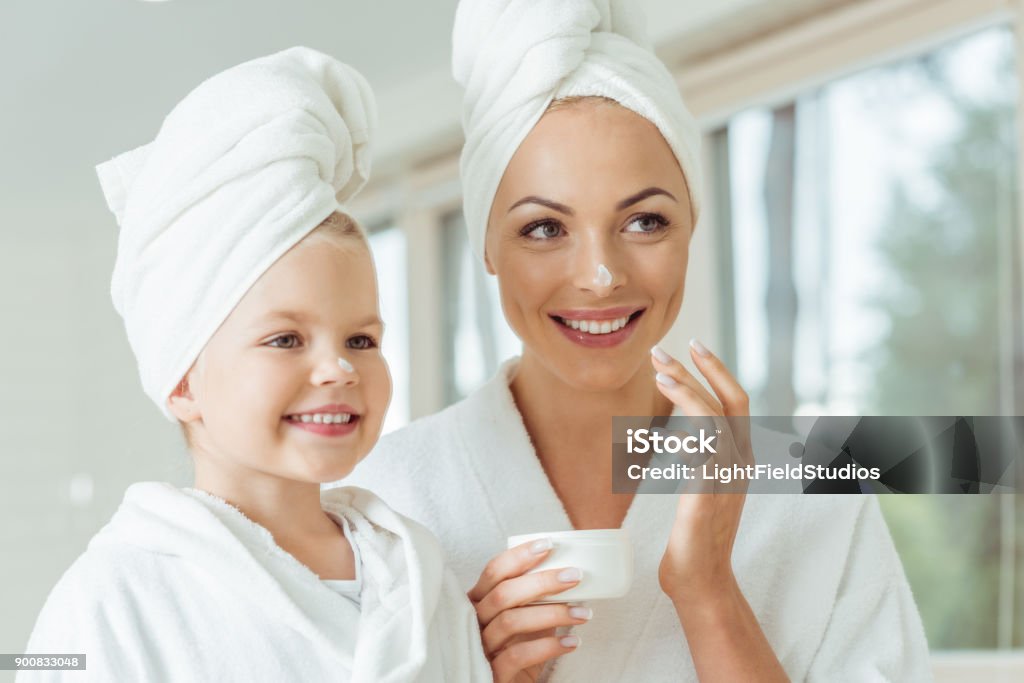 madre e hija aplicar Crema para la cara - Foto de stock de Madre libre de derechos