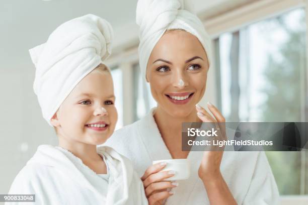 Mother And Daughter Applying Face Cream Stock Photo - Download Image Now - Mother, Daughter, Skin Care