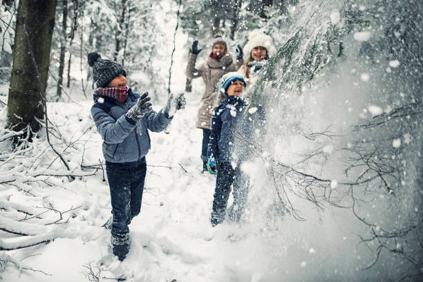 istock Family playing in winter forest 900836974