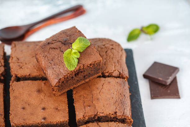 istock Pieces of dark chocolate brownie on slate board. 900837720