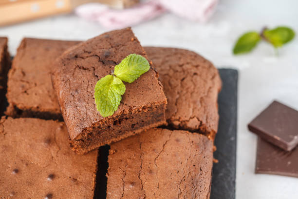 istock Pieces of dark chocolate brownie on slate board. 900839588