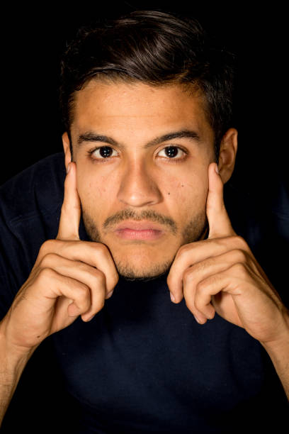 istock Man Close-up Portrait Looking Camera Serious Resting Both Hands on Face 900839836