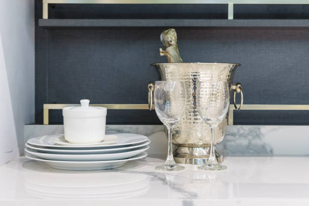 istock modern kitchen counter with bottles of Champagne in cooler, kitchenware on a white granite worktop 900839860