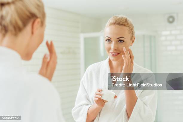 Woman In Bathrobe Applying Face Cream Stock Photo - Download Image Now - Face Cream, Applying, Skin Care