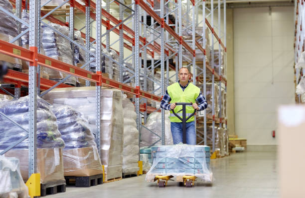 istock man carrying loader with goods at warehouse 900840374