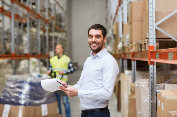 istock happy businessman with clipboard at warehouse 900840536