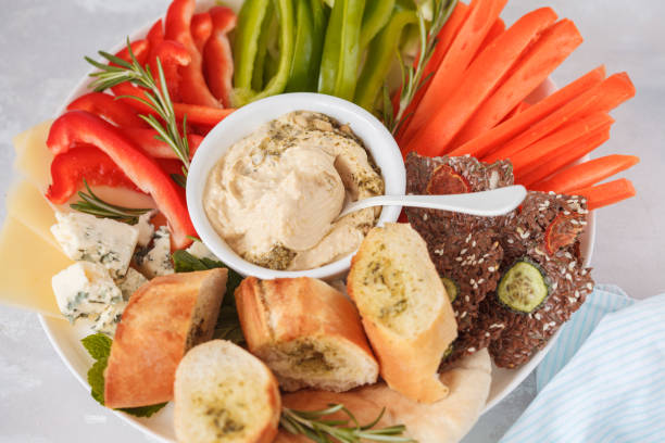 istock Plate with appetizers for hummus, vegetables, crispy bread, garlic baguette, parmesan, brie cheese. 900841132