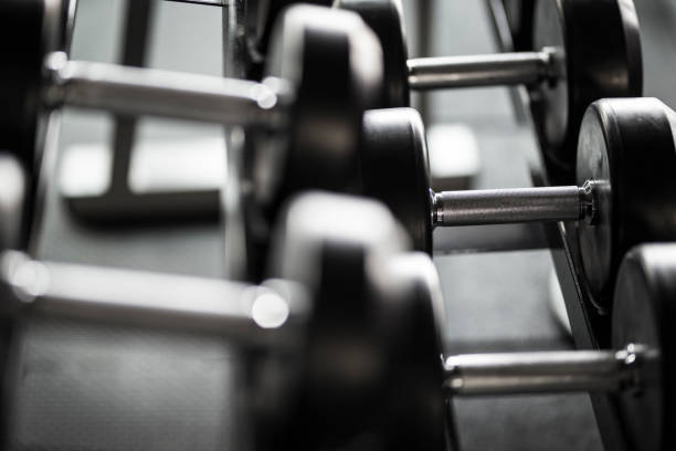 istock Dumbbells on Rack in Gym.Black and white background 900841262