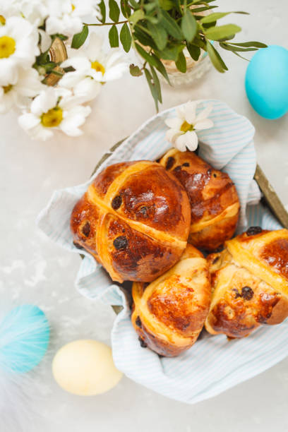istock Easter cross buns in a wooden box, painted eggs. Light background, copy space, top view. Easter food concept. 900841530