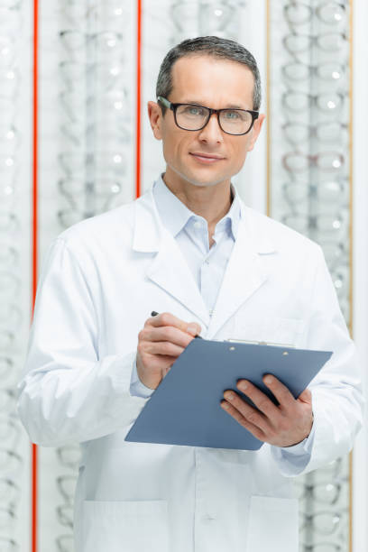 istock portrait of optometrist with notepad in hands looking at camera in optics 900841566