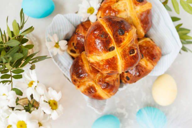 istock Easter cross buns in a wooden box, painted eggs. Light background, copy space, top view. Easter food concept. 900841592