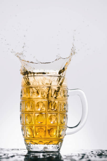 istock splashes of cold light beer in transparent glass 900845048